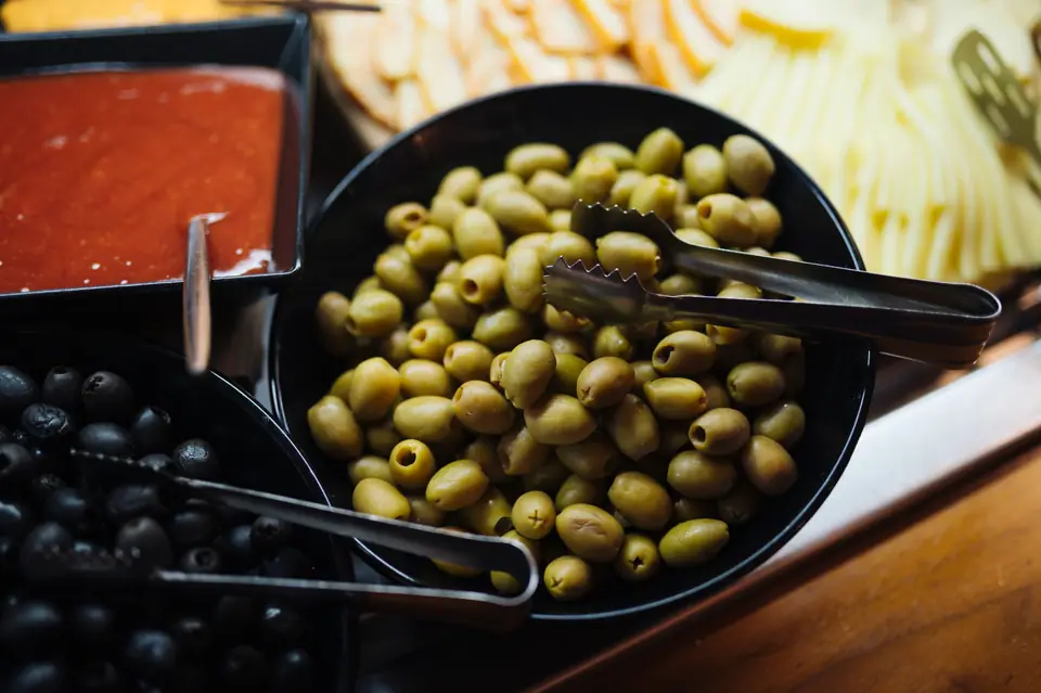 Aceitunas verdes y negras servidas en una mesa de aperitivos