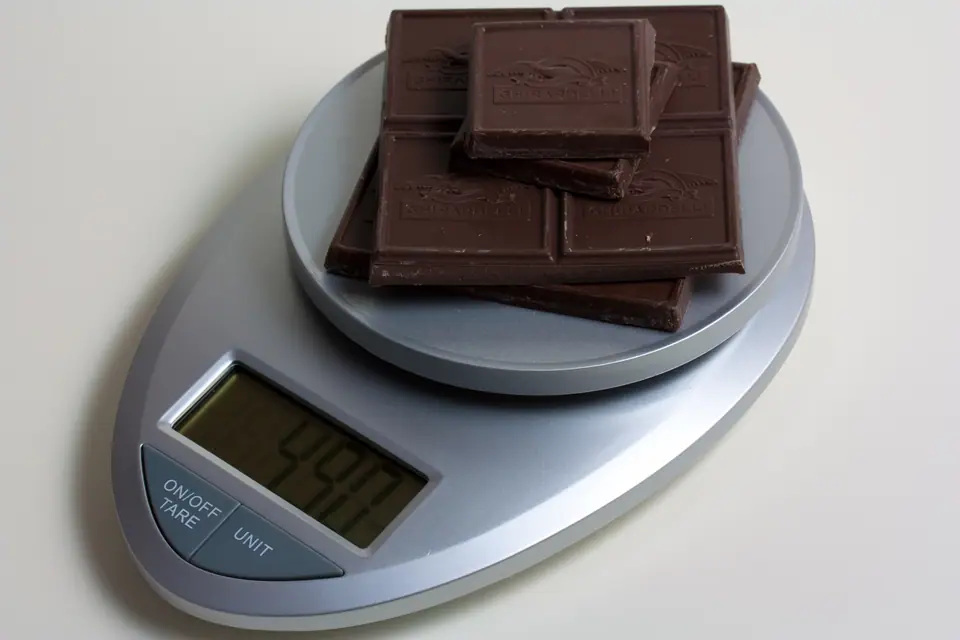 Balanza digital de cocina con barras de chocolate en el plato
