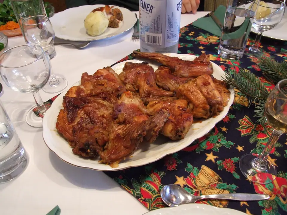 Presas de conejo asado, bien doradas, en una fuente sobre la mesa