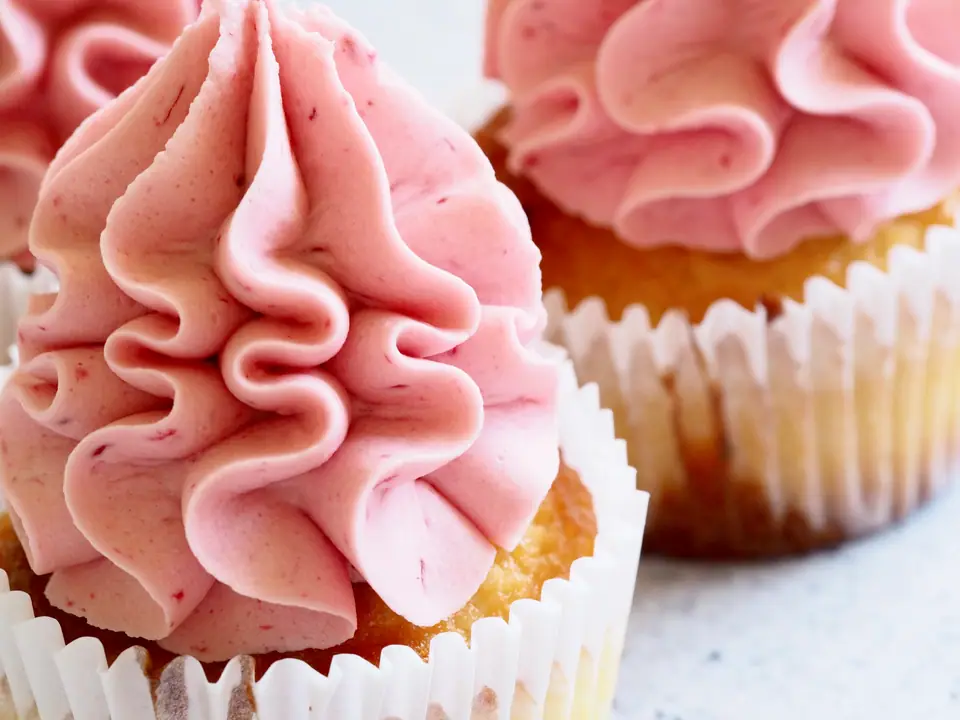 Cupcakes en pirotines de papel con copete de crema rosada