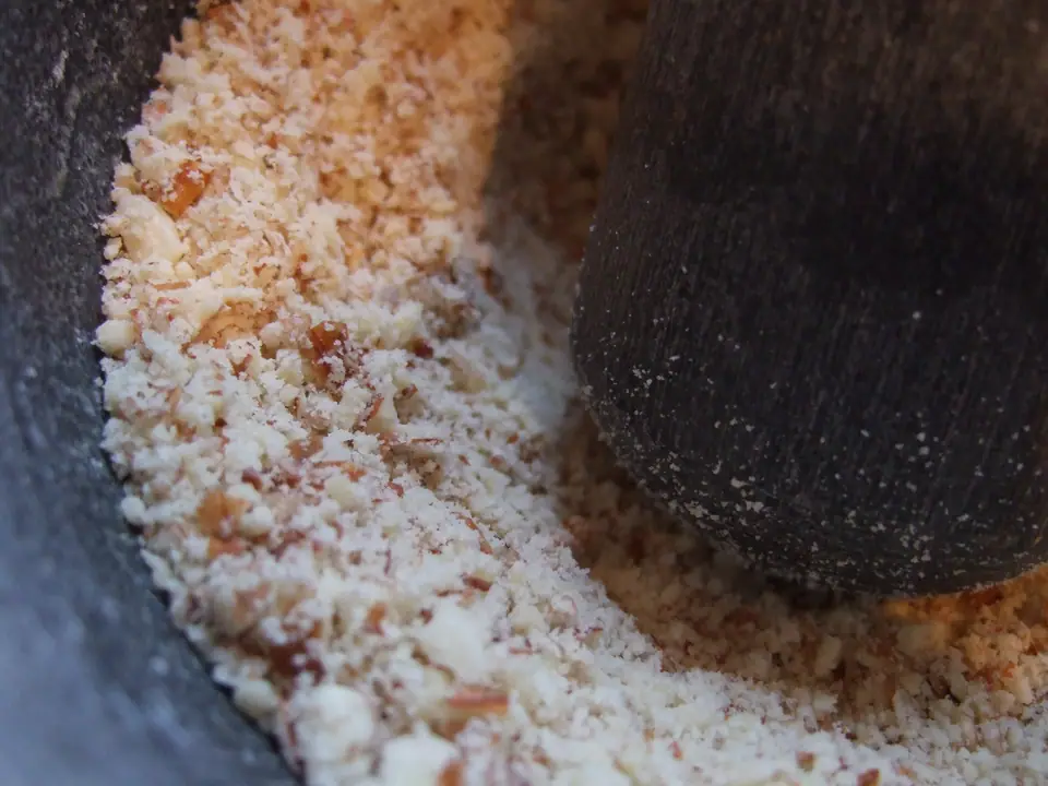 Almendras molidas a mano en un mortero, con textura de harina gruesa