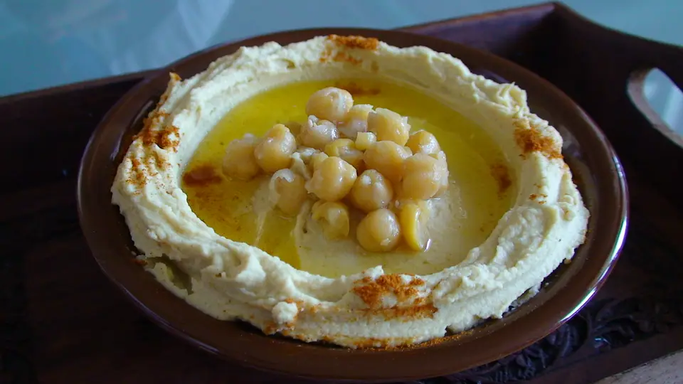 Plato de hummus con aceite de oliva, garbanzos enteros y pimentón por encima