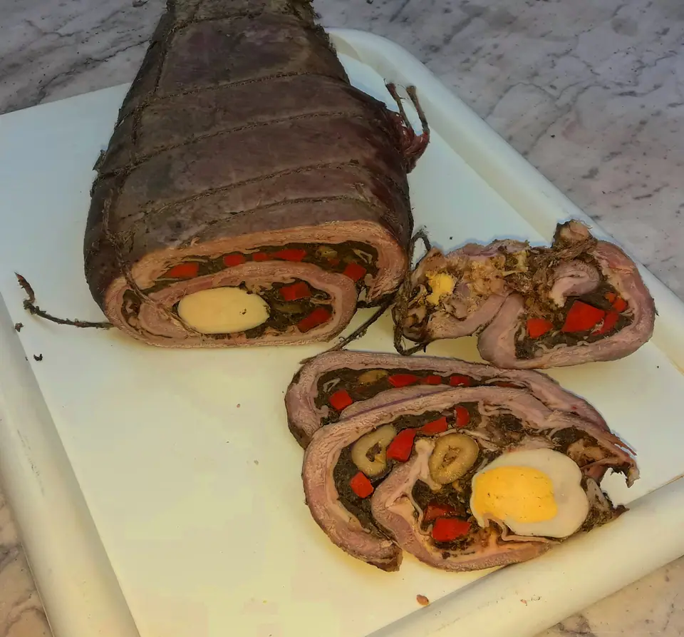 Matambre relleno arrollado y atado, con rodajas cortadas que muestran el relleno de verduras, morrón y huevo duro
