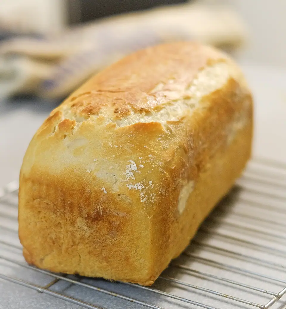 Pan de molde casero recién horneado sobre una rejilla