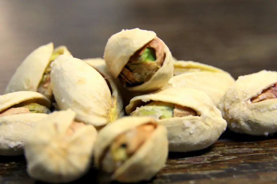 Pistachos con la cáscara entreabierta, mostrando el fruto verde
