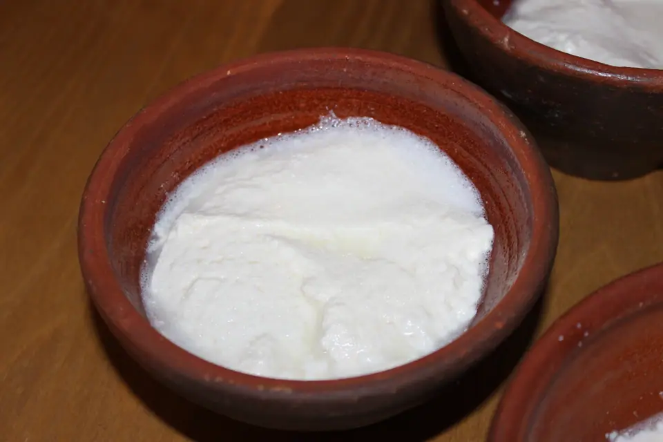Ricota fresca en cuencos de barro sobre una mesa de madera