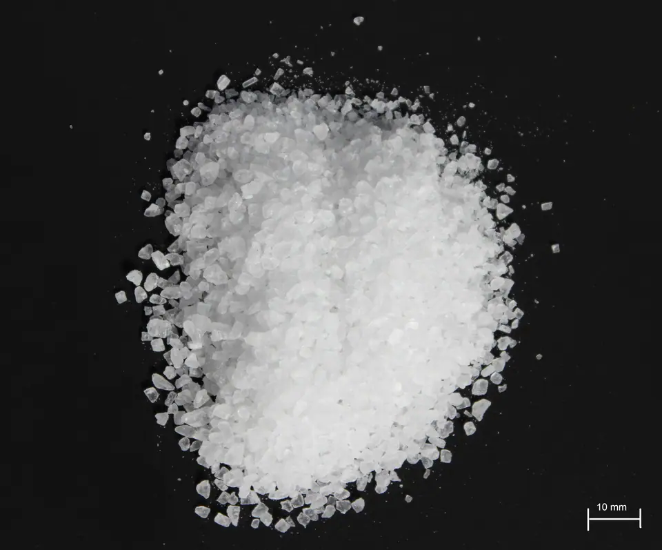 Montoncito de sal gruesa en granos sobre fondo negro