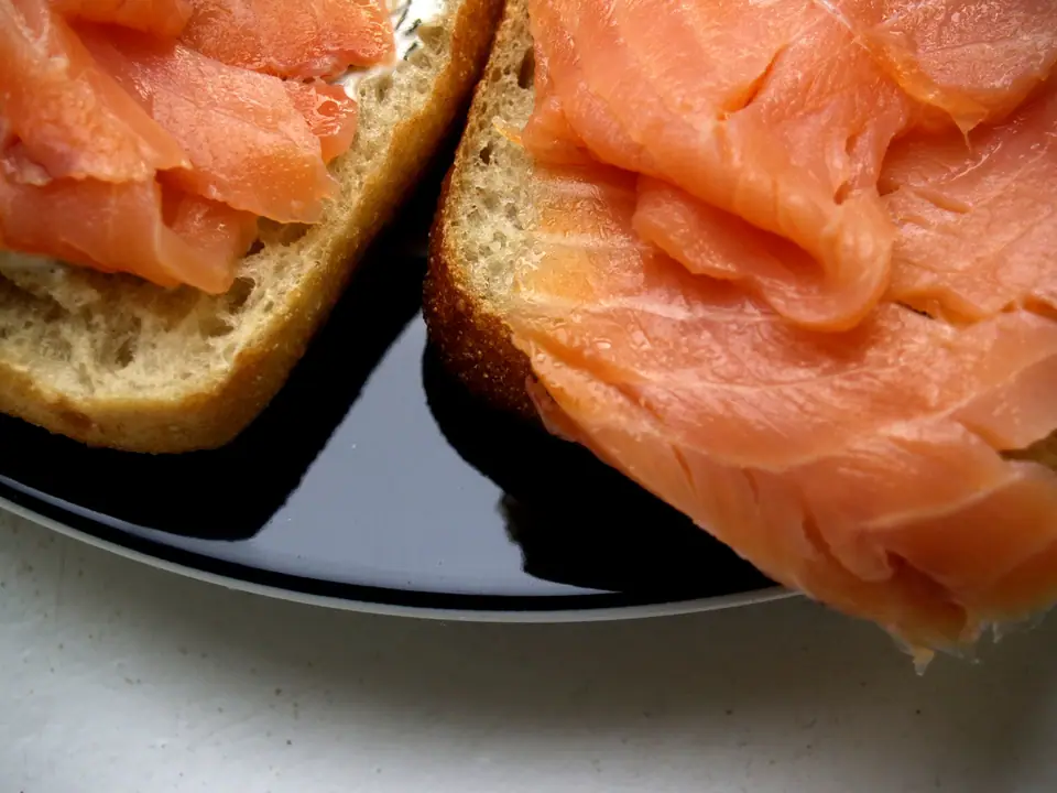 Lonjas de salmón ahumado sobre rebanadas de pan, en primer plano