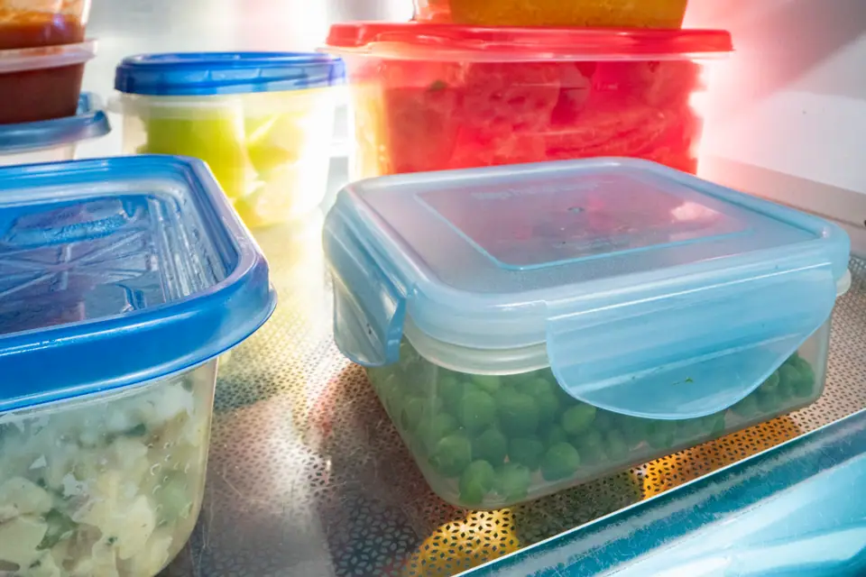 Recipientes plásticos tapados con comida guardada en la heladera